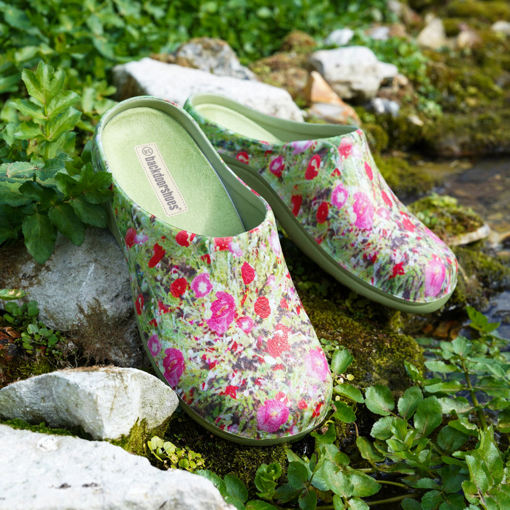 a pair of clogs placed by a stream 
